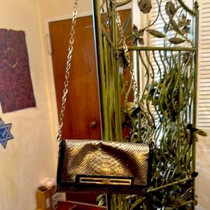 Nine West Silver, Snake print clutch.Frontal metal is rubbed.